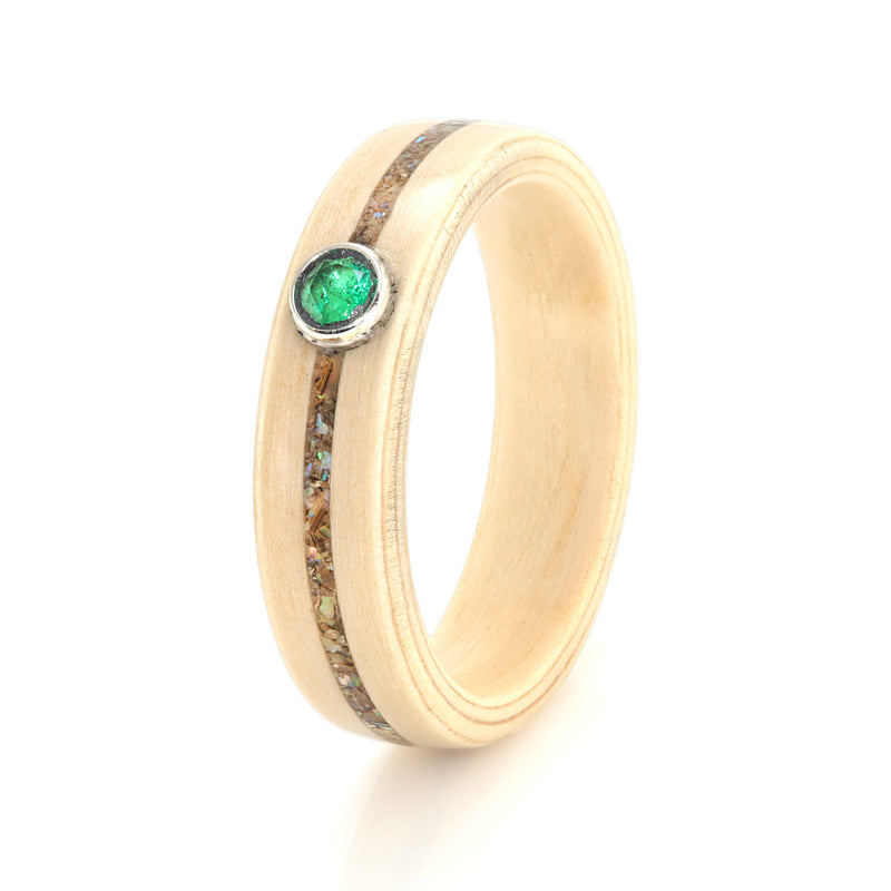 Apple wood non traditional engagement ring with an inlay of paua shell meeting at a round emerald in a bezel setting