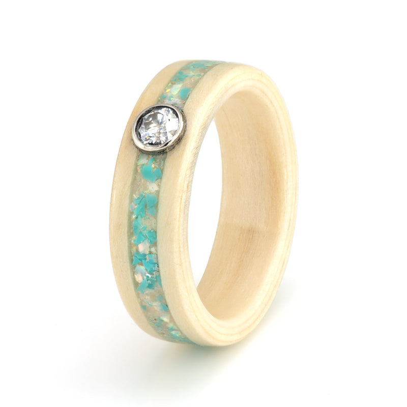 Apple wood ring with an inlay of sunstone, moonstone, opal and turquoise meeting at a round moissanite in a white gold bezel