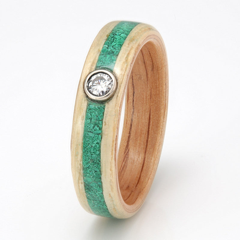 Ash wooden engagement ring with an oak liner and a centred inlay of malachite meeting at a moissanite in a bezel setting