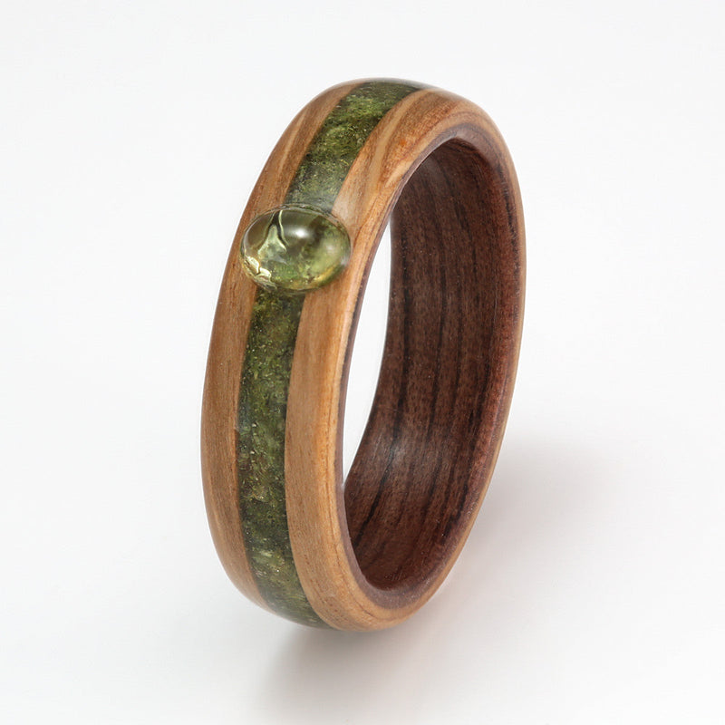 Non metal engagement ring | Oak wood ring with a walnut liner and a centred inlay of moss meeting at an oval peridot stone