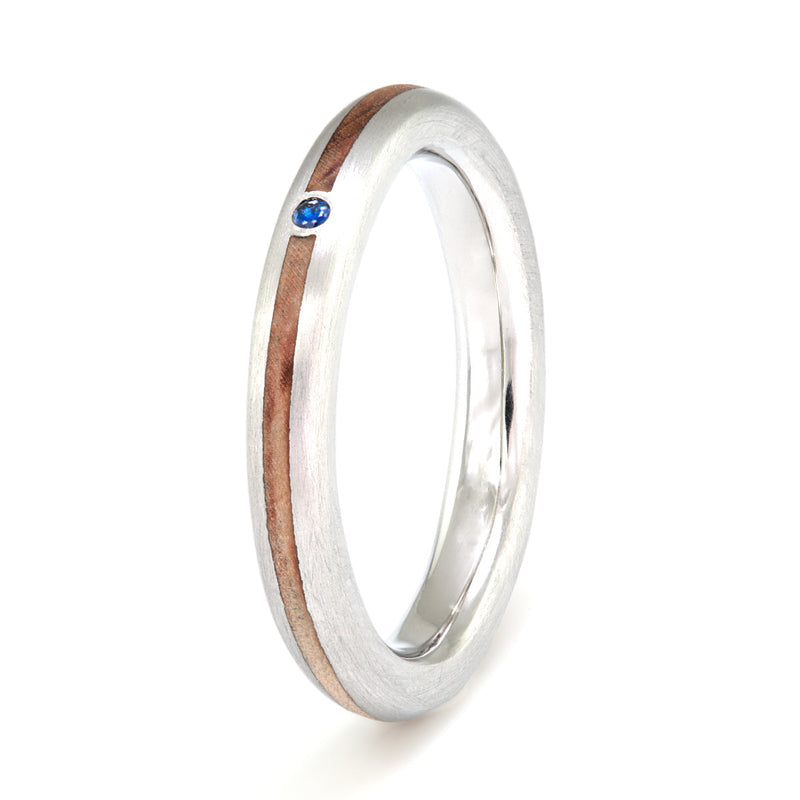 Platinum engagement ring | 3mm wide rounded edge platinum ring with a 1mm wide centred wood inlay and a small round sapphire